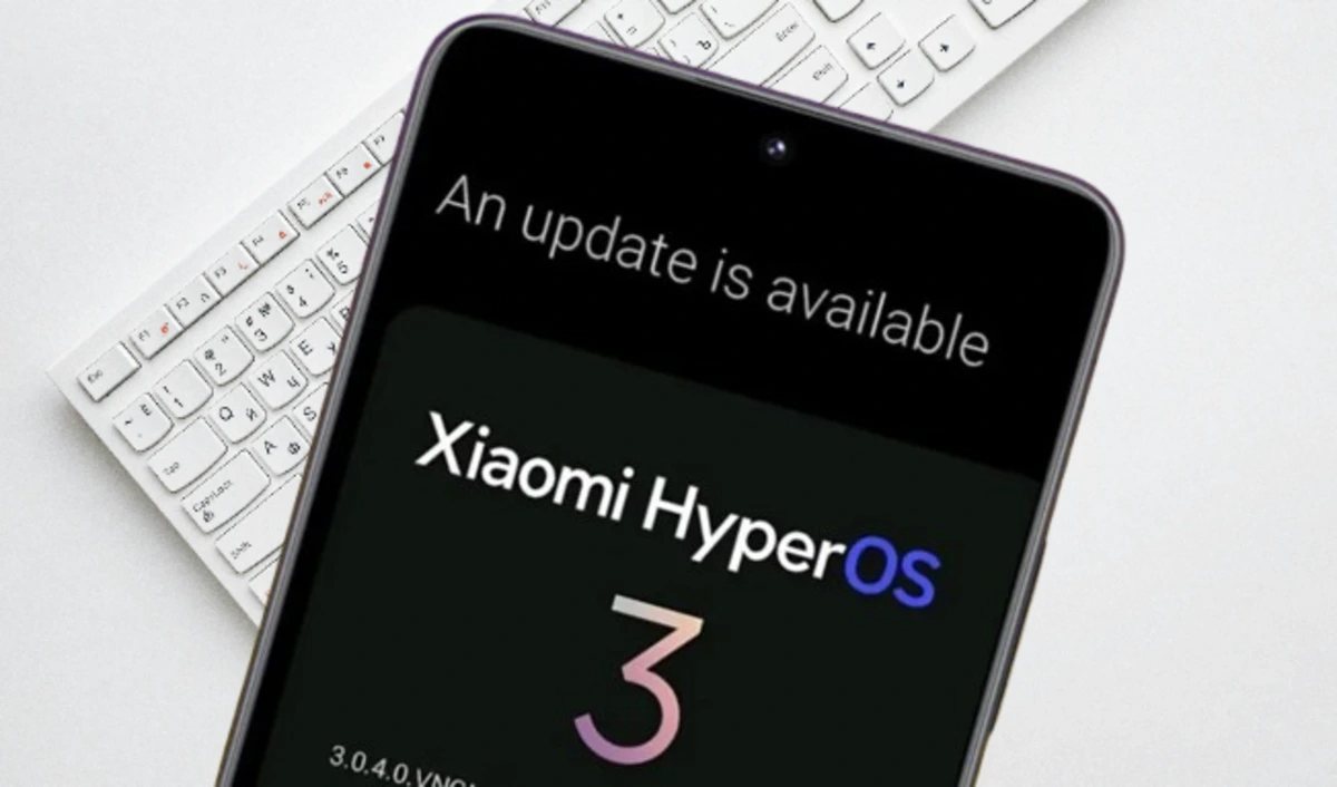 Smartphone Xiaomi com tela exibindo "Xiaomi HyperOS 3 Global" e uma notificação de atualização disponível.