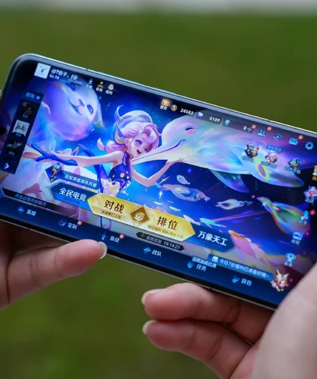 Mãos segurando um smartphone Xiaomi exibindo um jogo com gráficos vibrantes, demonstrando a Nova Atualização Game Turbo da Xiaomi.