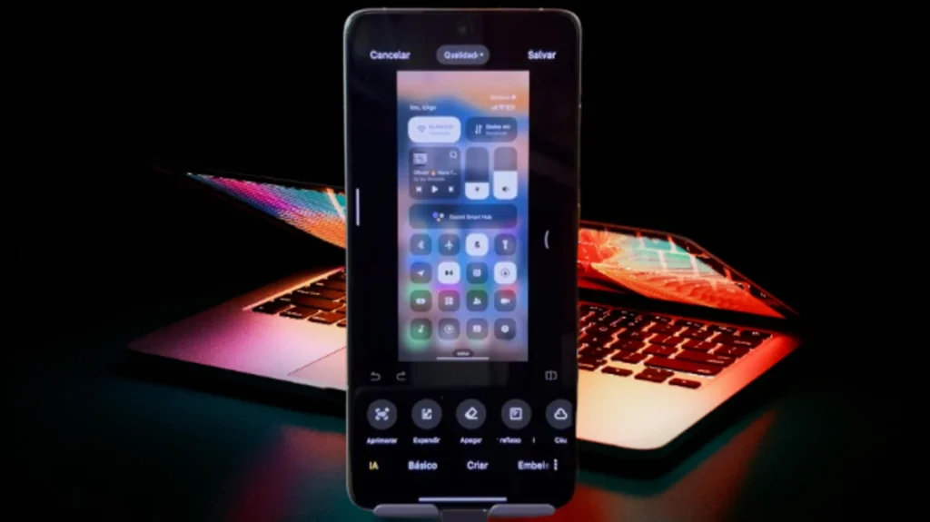 Smartphone exibindo o editor de imagens em um dos novos apps do HyperOS 2.2, com um laptop brilhando ao fundo.