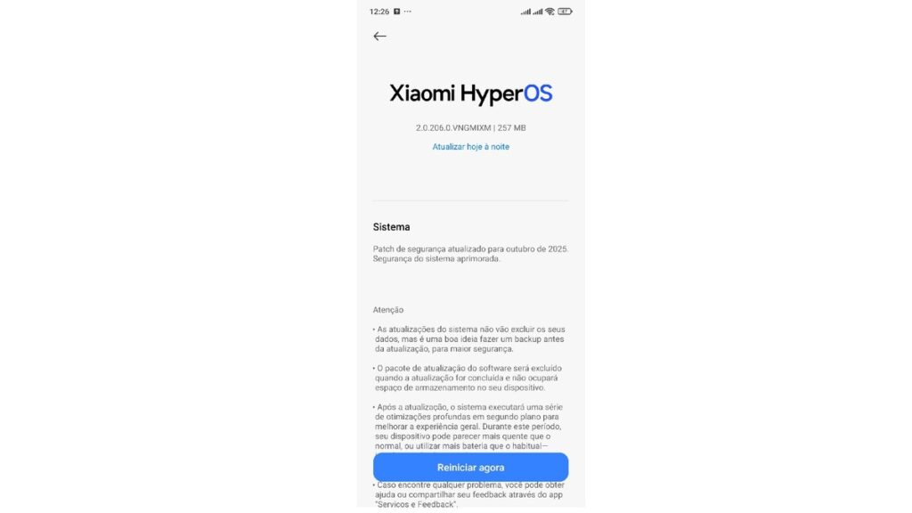 A imagem apresenta a tela de um smartphone focada na interface de atualização do Xiaomi HyperOS. No topo, o título 'Xiaomi HyperOS' é exibido com o número da versão '2.0.206.0.VNGMIXM' e o tamanho de 257 MB. Há um link em azul claro 'Atualizar hoje à noite'. A seção 'Sistema' informa sobre um 'Patch de segurança atualizado para outubro de 2025' e 'Segurança do sistema aprimorada'. Abaixo, em 'Atenção', são fornecidas três observações importantes: a primeira aconselha fazer backup antes da atualização para evitar perda de dados, a segunda menciona que o pacote de atualização será excluído após a instalação para economizar espaço, e a terceira alerta sobre um possível aumento no uso de bateria ou aquecimento durante as otimizações pós-atualização. Um botão azul proeminente 'Reiniciar agora' está centralizado na parte inferior da tela, e uma nota final instrui o usuário a enviar feedback através do aplicativo 'Serviços e feedback' em caso de problemas. Esta imagem detalha o processo de atualização do HyperOS 2.2 no Redmi Note 13 4G.