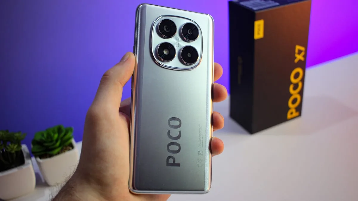 Smartphone POCO X7 na cor prata, recebendo o HyperOS 3 Global, destaque para o módulo de câmeras traseiras e a caixa do aparelho ao fundo.